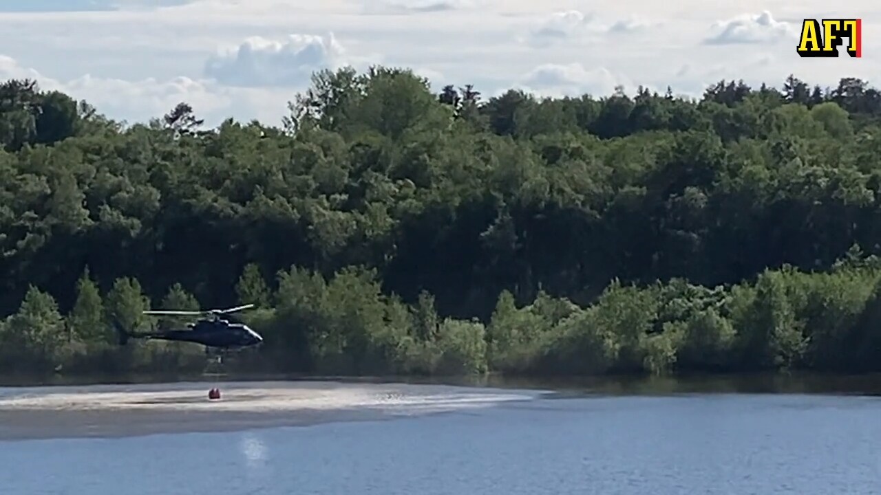 Här hämtar helikoptern vatten i sjö för att vattenbomba branden