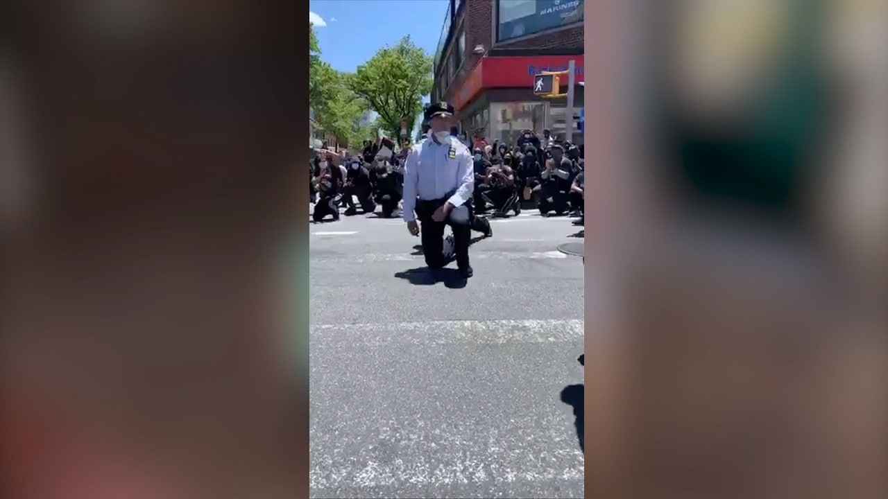 Här går poliserna ner på knä med demonstranterna