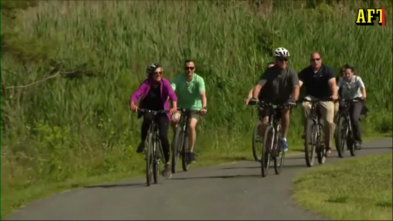 Här ramlar presidenten när han försöker kliva av cykeln