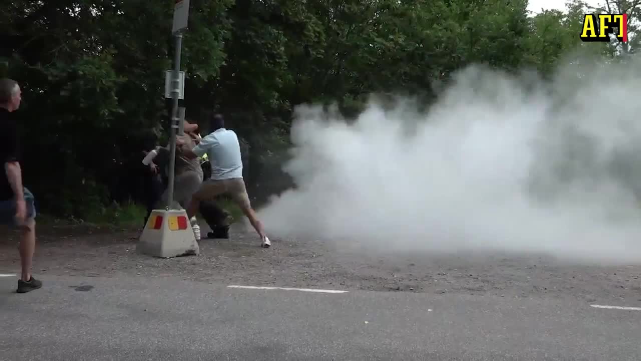 Här rusar kvinnan fram med brandsläckaren under koranbränningen