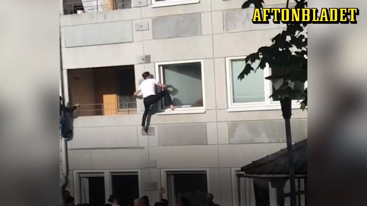 Här räddas kvinnan av sina grannar ur det brinnande huset