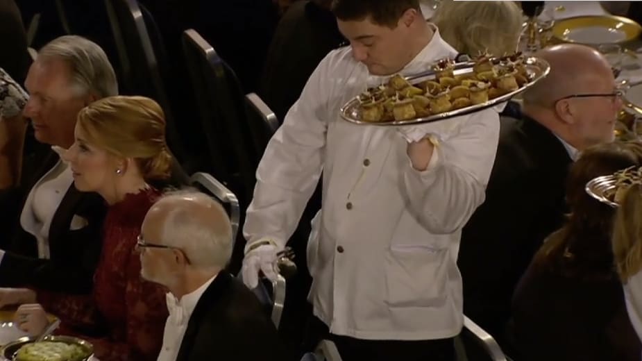 Här tappar servitören maten på professorn under Nobelfesten