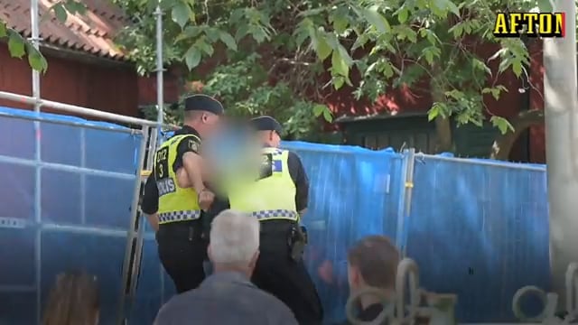 Här omhändertas en man vid koranbränningen