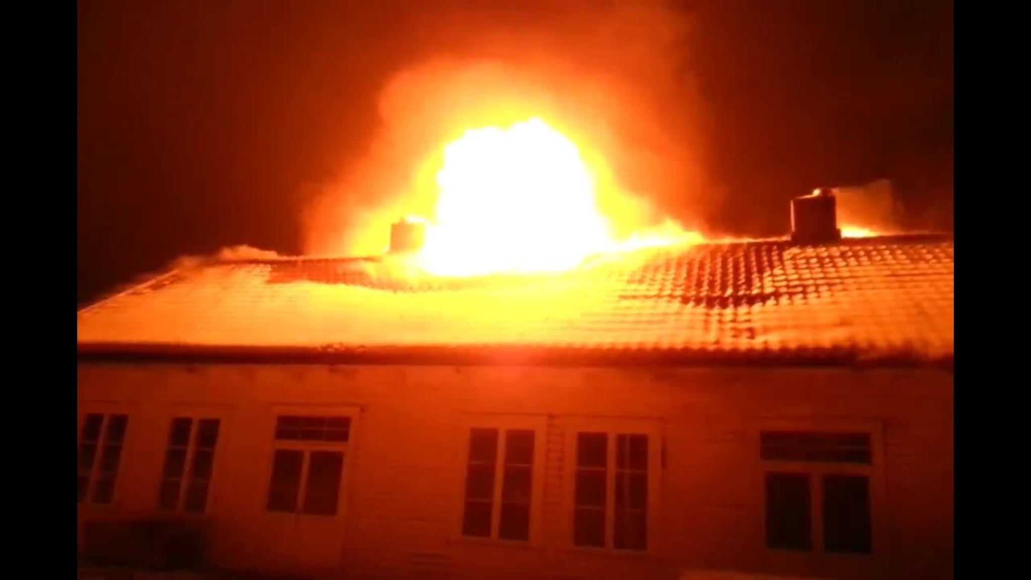 Her slår flammene ut av huset