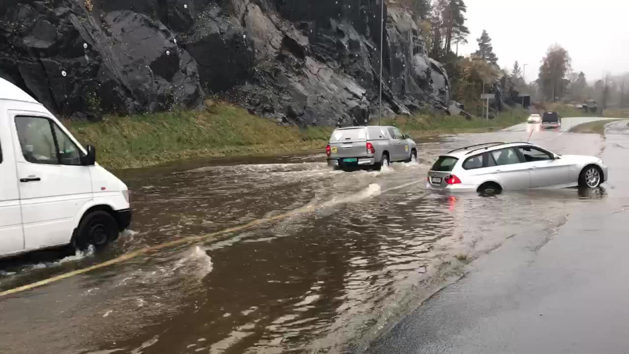 Biler kjører igjennom vannmassene på E 18