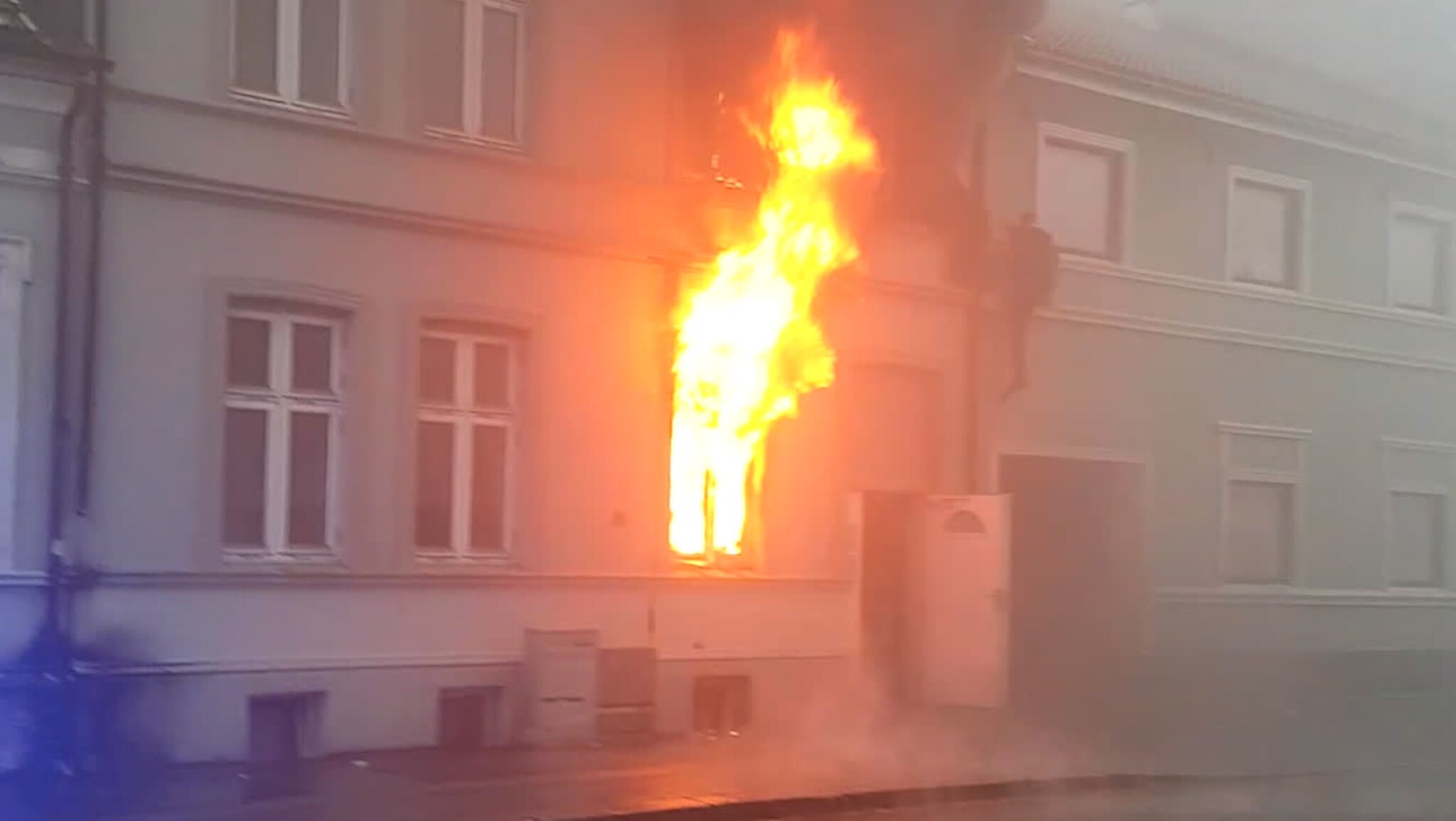 Her hopper han fra den brennende bygården