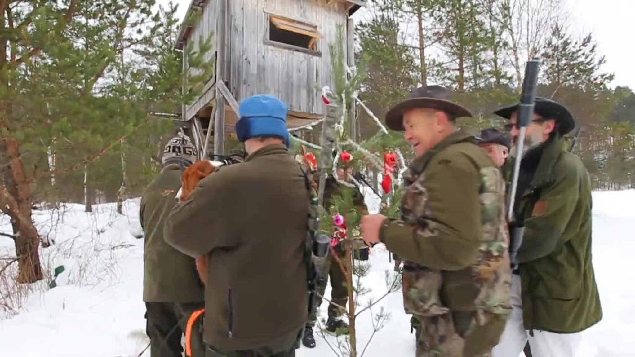 Se jegerne gå rundt juletreet i skogen