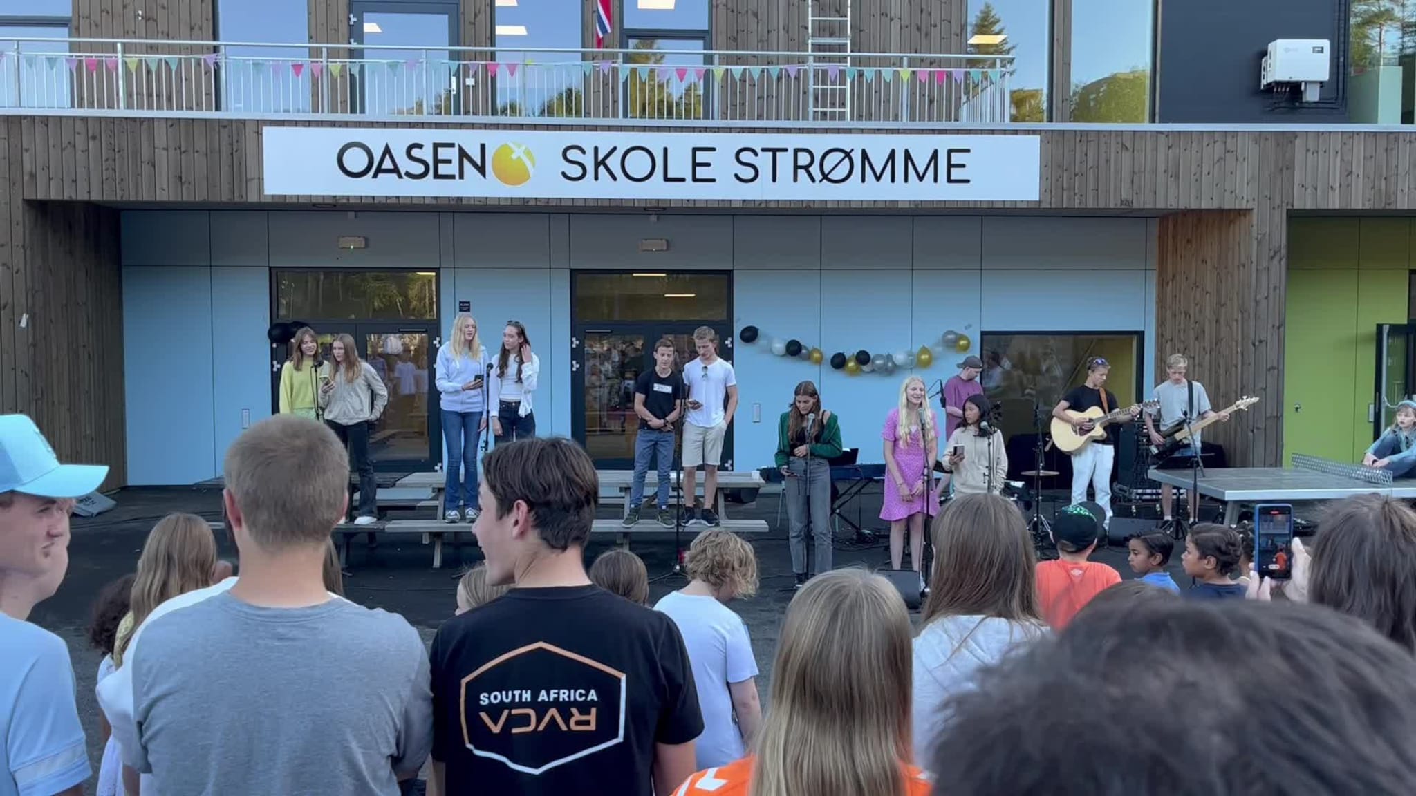 Her synger Oasen-elever under åpningen av skolebygget