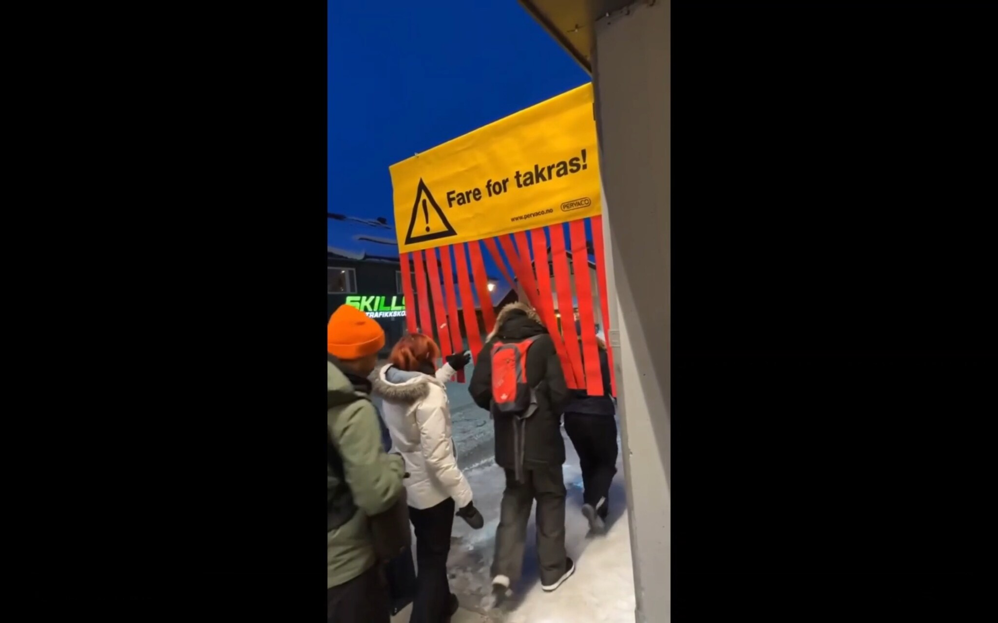 turister går under takras-skilt